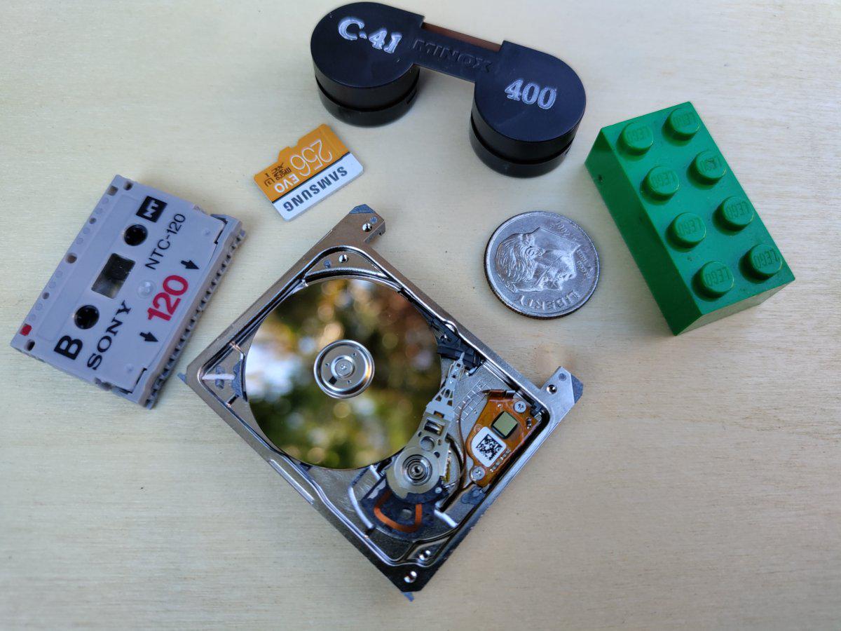 Four pieces of tiny media with a dime and Lego brick for scale